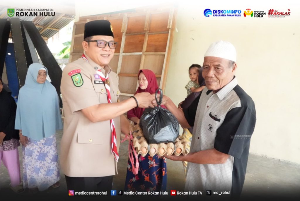 Bupati Rokan Hulu H. Sukiman saat menyerahkan bantuan sosial kepada warga dalam rangka penyaluran bantuan di wilayah Kabupaten Rokan Hulu, Kamis (6/8/2026).